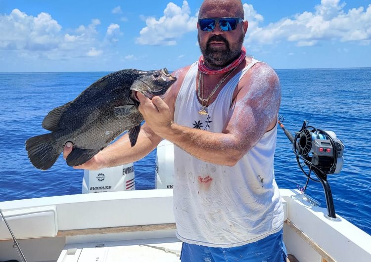 man holding a fish on a boat